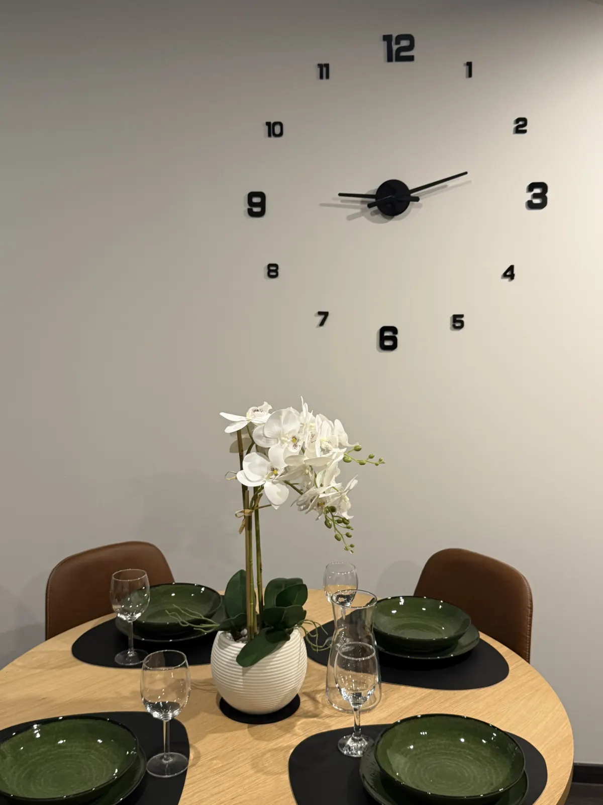 Nakryty stół z kwiatkiem i zegarem w apartamencie